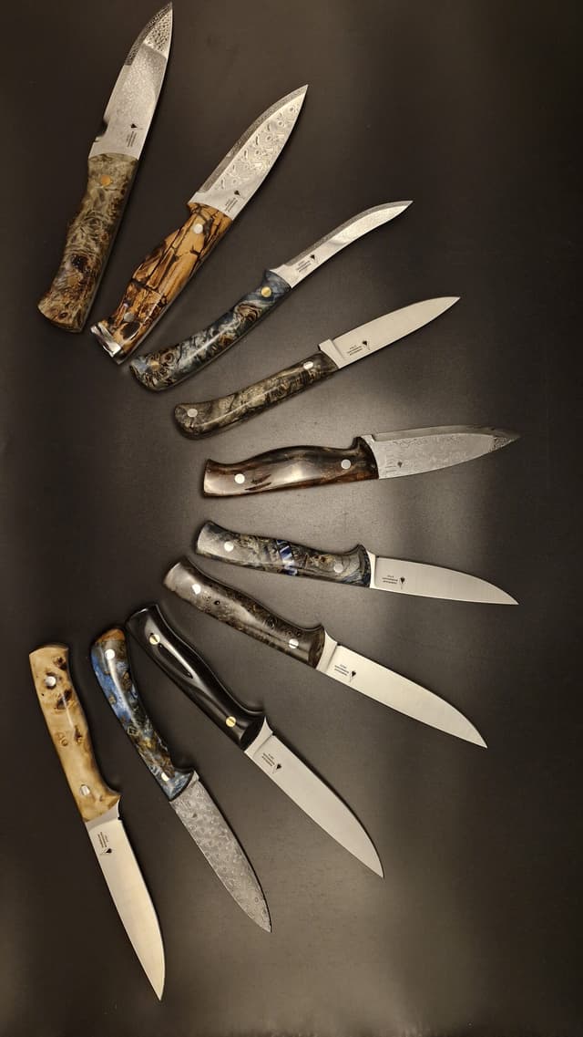 Knives fanned in an arc on a dark ground, handles inward