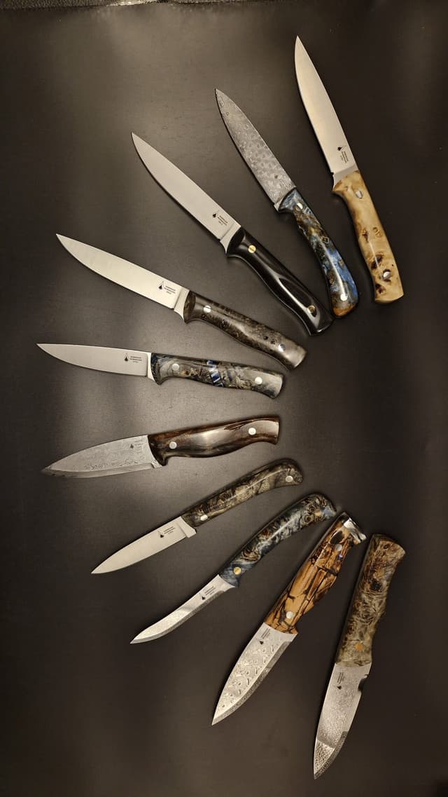 Finished knives fanned in an arc on a dark ground