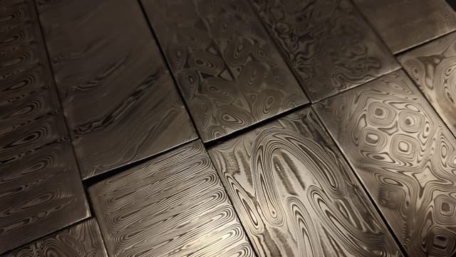 Several Damascus billets laid side by side under a raking light