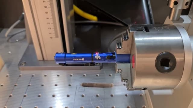 A cylindrical piece held in the laser engraver’s rotary chuck