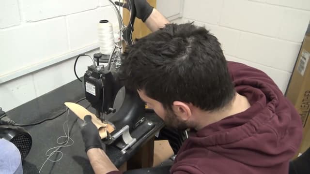 A sheath being stitched on the leather machine