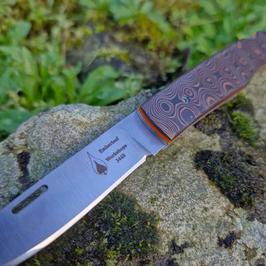 Close view of an Aquila lock back blade, project 3448, flat ground from the spine with a fine micro bevel along the edge