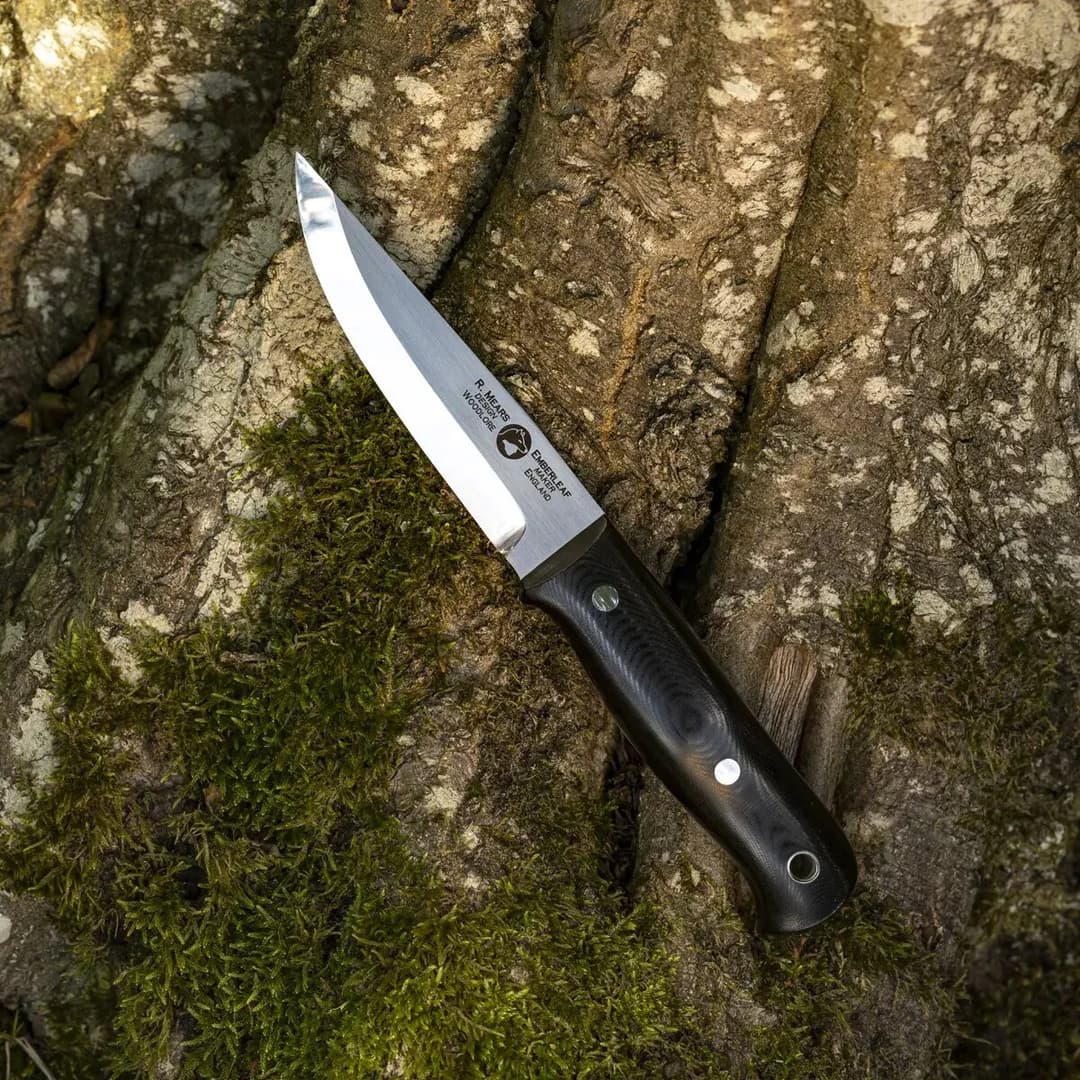 A Woodlore Pro on a mossy tree trunk, the blade marked R. Mears Design Woodlore and Emberleaf Maker England