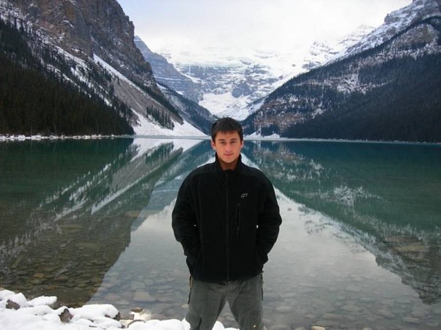 Joel Andreas standing at the edge of a mountain lake